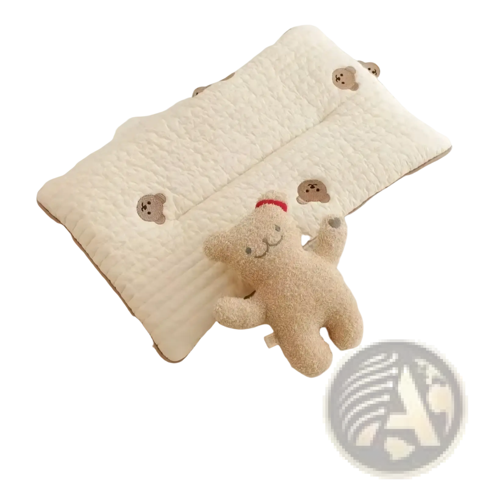Cream-colored quilted embroidered cotton baby pillow with brown bear faces next to a plush beige teddy bear in red hat