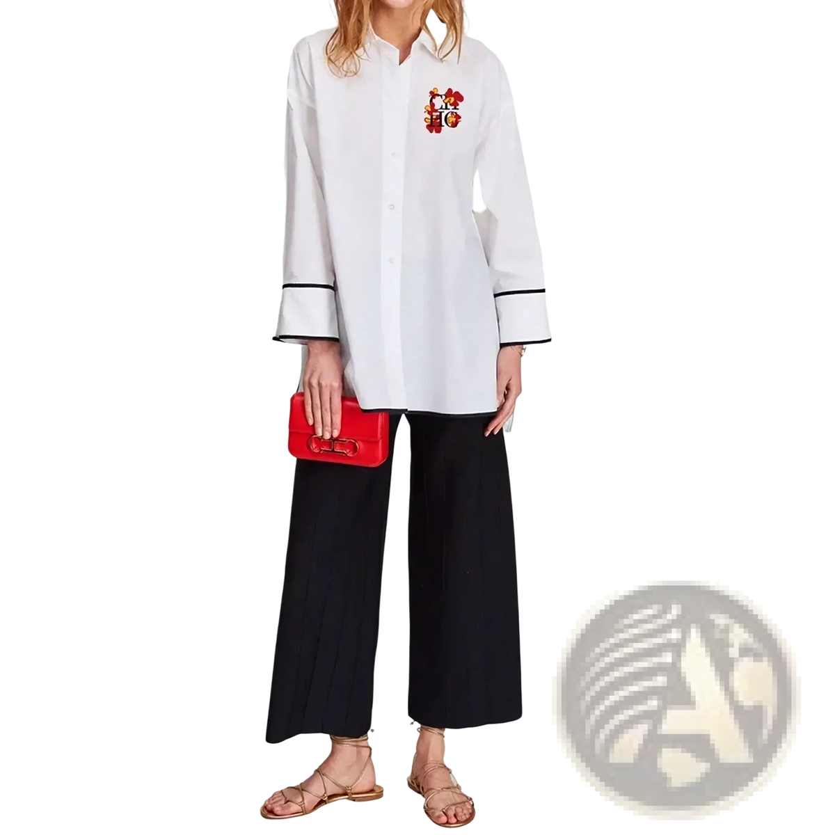 A vibrant red leather clutch with a distinctive gold tone clasp paired with an embroidered cotton blouse with black trim