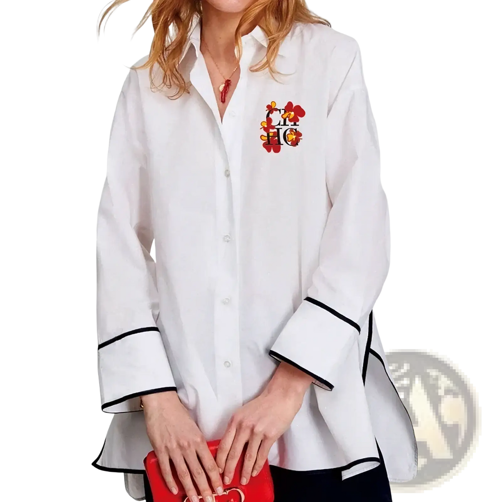 White oversized cotton blouse with black trim on cuffs and hem featuring colorful embroidered logo on left chest