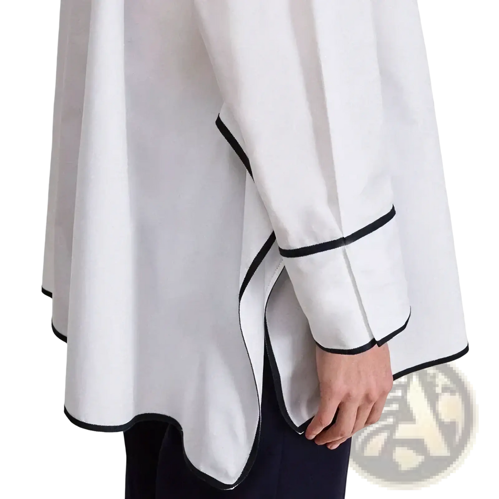 Embroidered cotton blouse with black trim featuring a flowing asymmetrical design and black cuffs and hem
