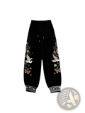 Black embroidered crane straight leg casual pants with white crane butterfly floral designs and rhinestone cuff trim