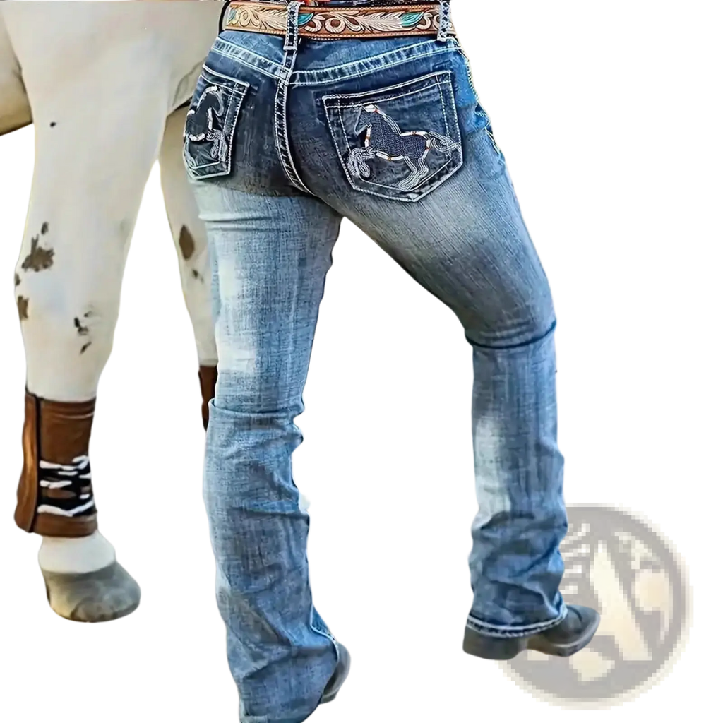 Back side of blue embroidered denim straight leg jeans with horse designs on pockets and decorative belt