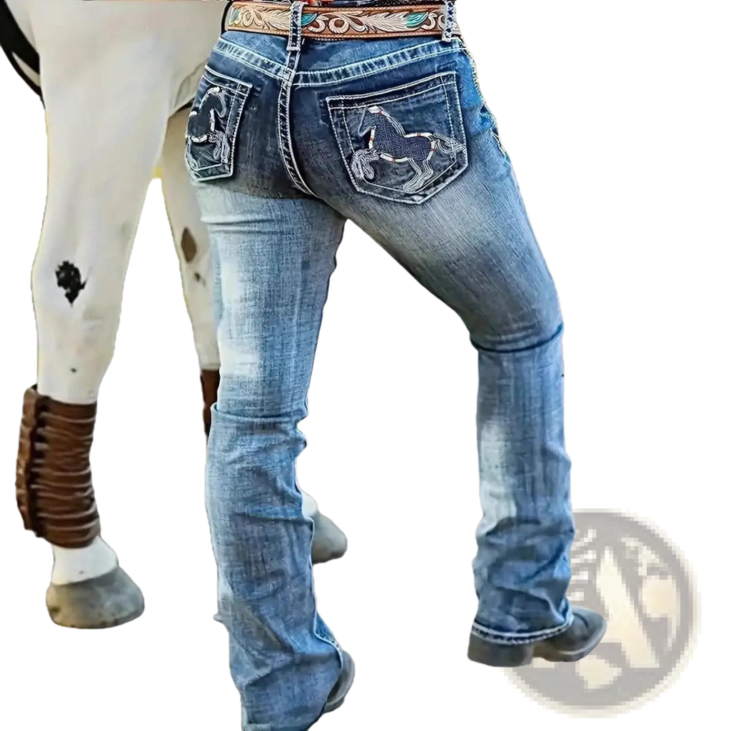 Blue denim straight leg jeans shown from the back with embroidered horse designs on pockets and floral belt