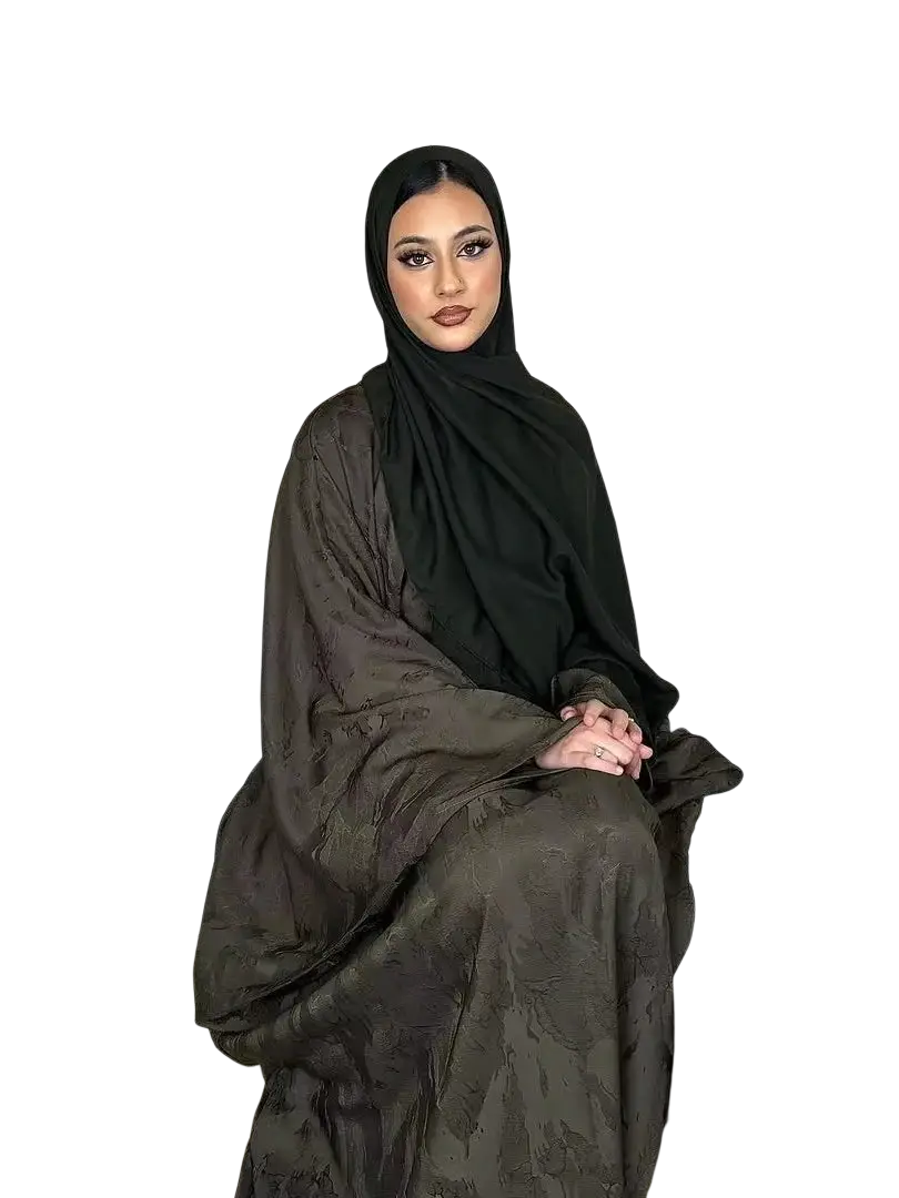 A woman wearing an olive-green embroidered floral abaya kaftan maxi dress with a black hijab