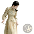 A woman wears a beige embroidered floral apricot cheongsam dress with long sleeves and a high collar featuring tassels