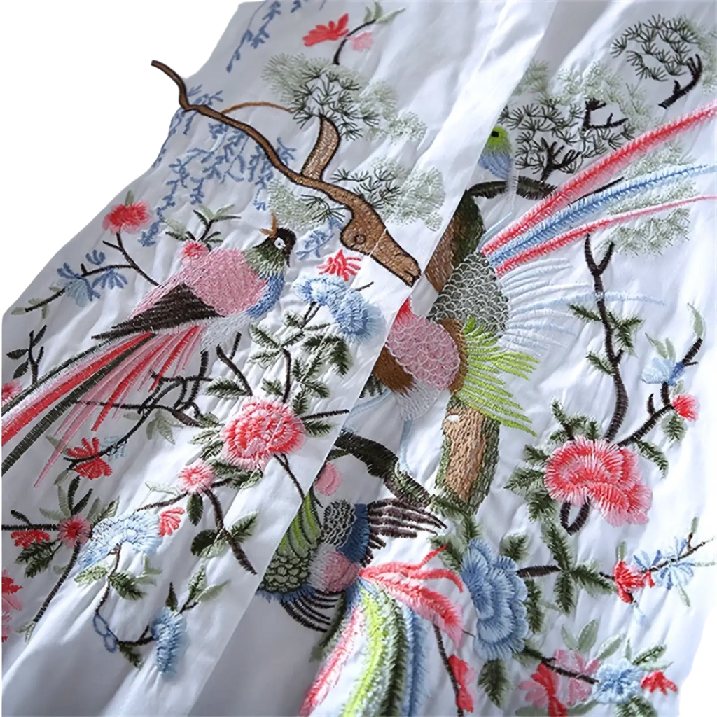 White chiffon blouse with intricate embroidered birds and flowers in vibrant pink blue green and red threads