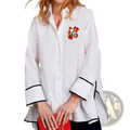 White cotton button up blouse with black trim on cuffs and hem and colorful floral embroidery on left chest