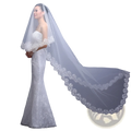 A flowing white lace cathedral wedding veil with delicate embroidered floral edges for bridal use