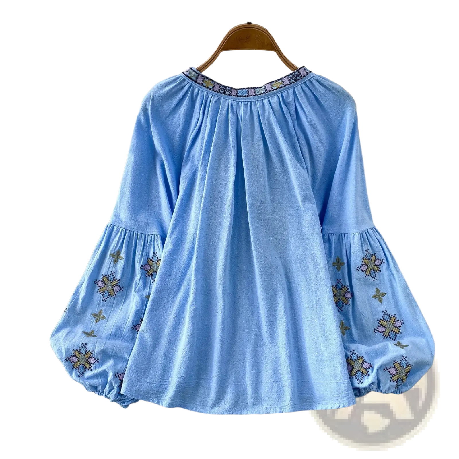 Light blue embroidered lantern sleeve blouse with puff sleeves and patterned neckline in lightweight fabric