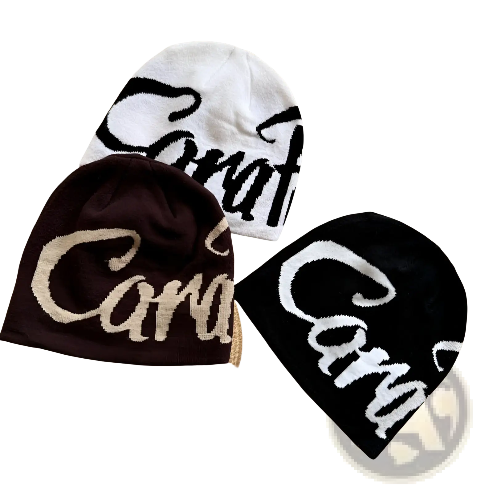 Three knitted embroidered letter knit beanie hats in white, dark brown, and black featuring cara logo designs