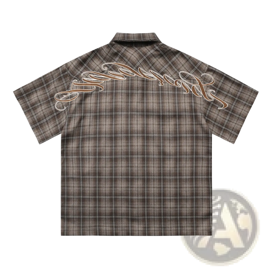 Back view of a dark brown and black plaid short sleeve button up shirt with embroidered cursive logo across the back