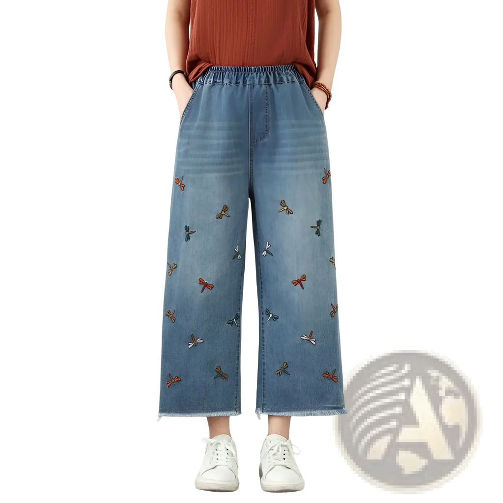 Light blue denim wide-leg jeans featuring colorful embroidered dragonflies in red orange and teal