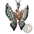 A gold-toned emerald angel wing butterfly pendant necklace with intertwined figures and gemstone accents suspended from a chain