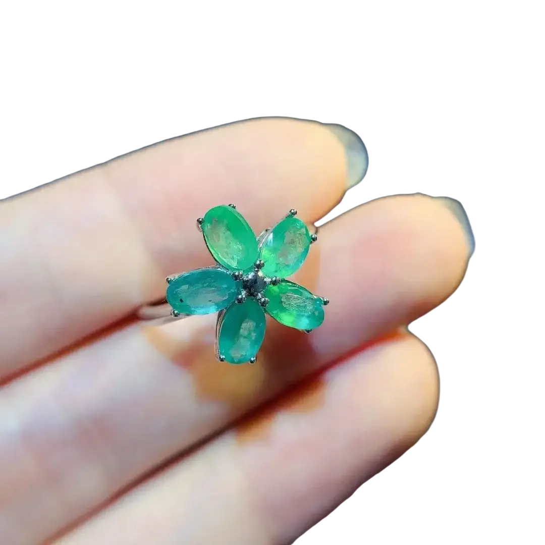 A delicate emerald flower silver ring with five vibrant green gemstones set in sleek silver-toned metal