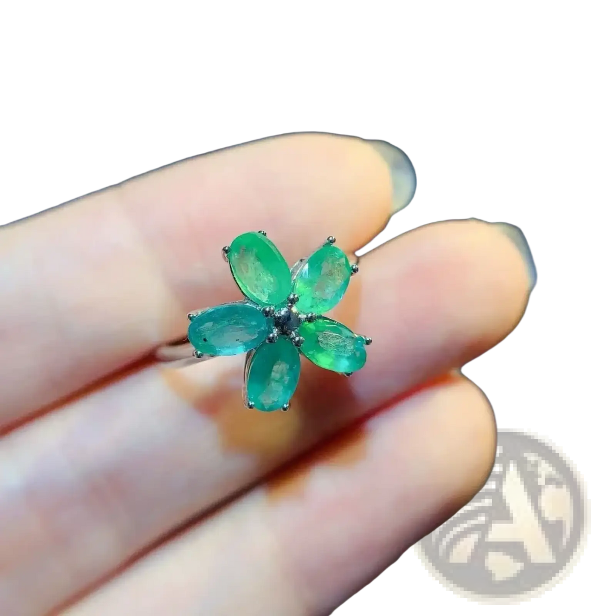 A delicate emerald flower silver ring with five vibrant green gemstones set in sleek silver-toned metal