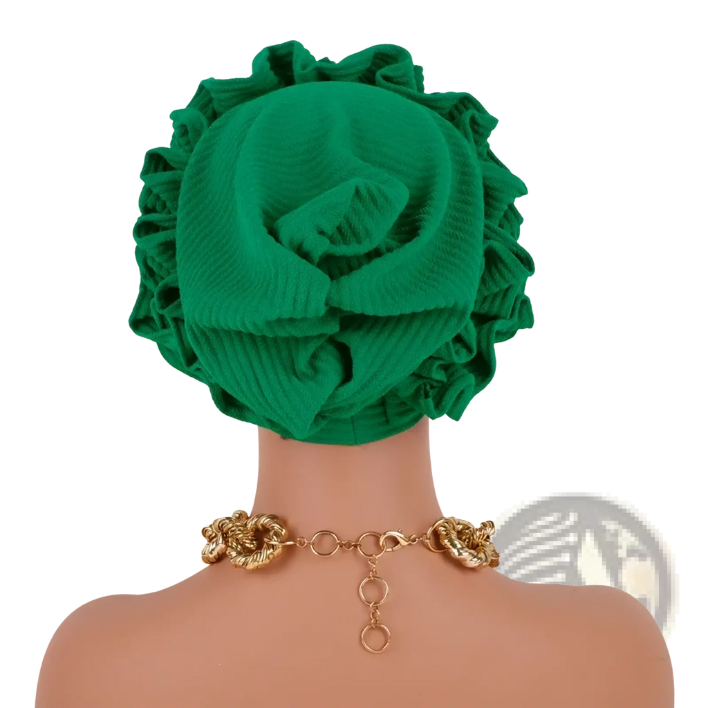 Emerald green ruffled turban cap with ribbed texture and voluminous flower-like folds in a soft fabric
