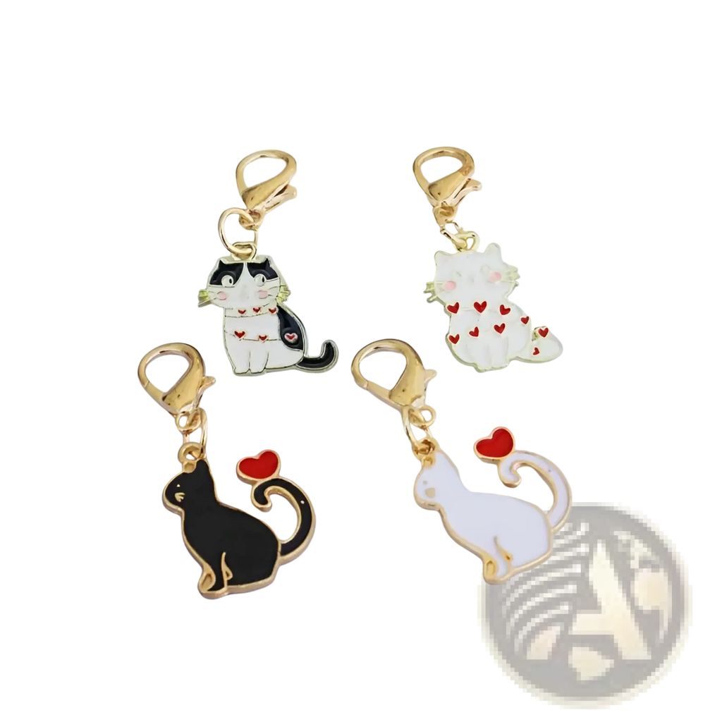 Four enamel cat keychains with gold-toned clasps in black-and-white, white with red hearts, solid black, and solid white designs
