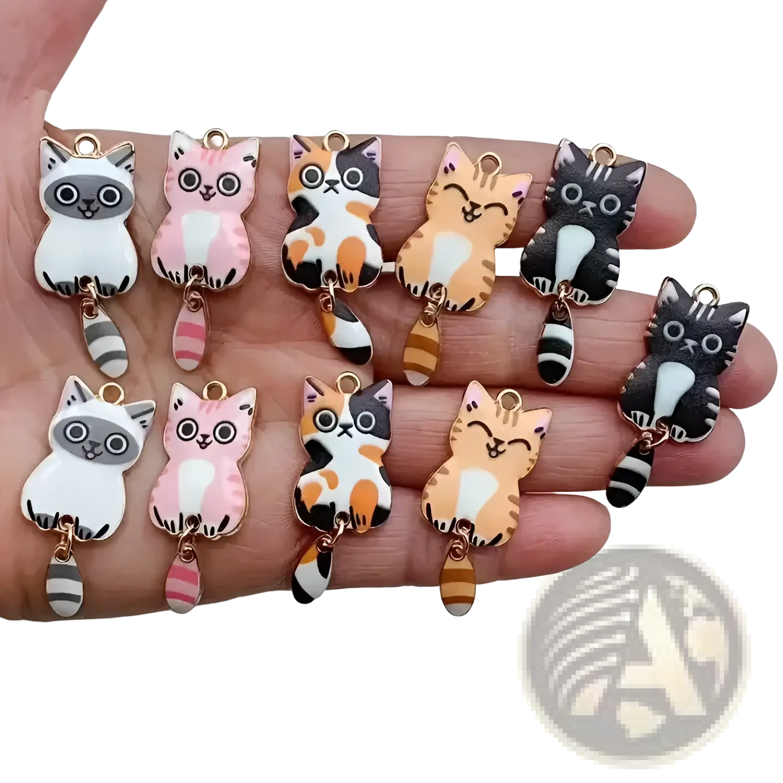 A hand holds colorful enamel cat keychain charms with gold metal loops and striped tails for cute accessories