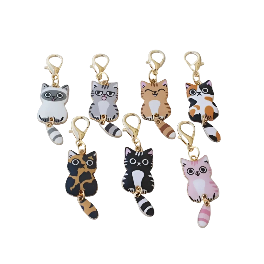 Set of seven colorful enamel cat keychains with striped tails and gold-toned clasps for cute charms collection