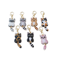 Set of seven colorful enamel cat keychains with striped tails and gold-toned clasps for cute charms collection