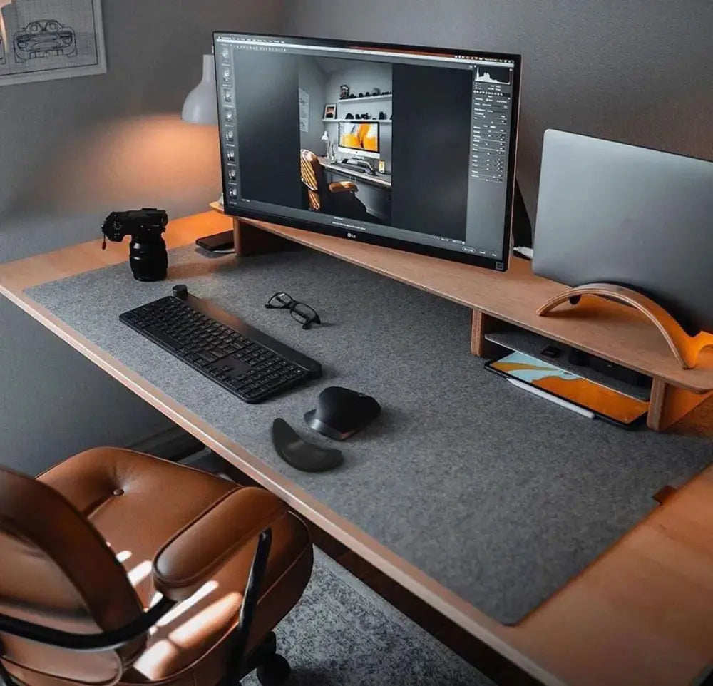 Gray felt desk mat with subtle texture placed under keyboard and mouse on wooden surface for ergonomic silicone gel mouse wrist rest with gliding base