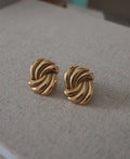 Eternal gold twisted knot stud earrings in gold tone with polished metallic finish and elegant design