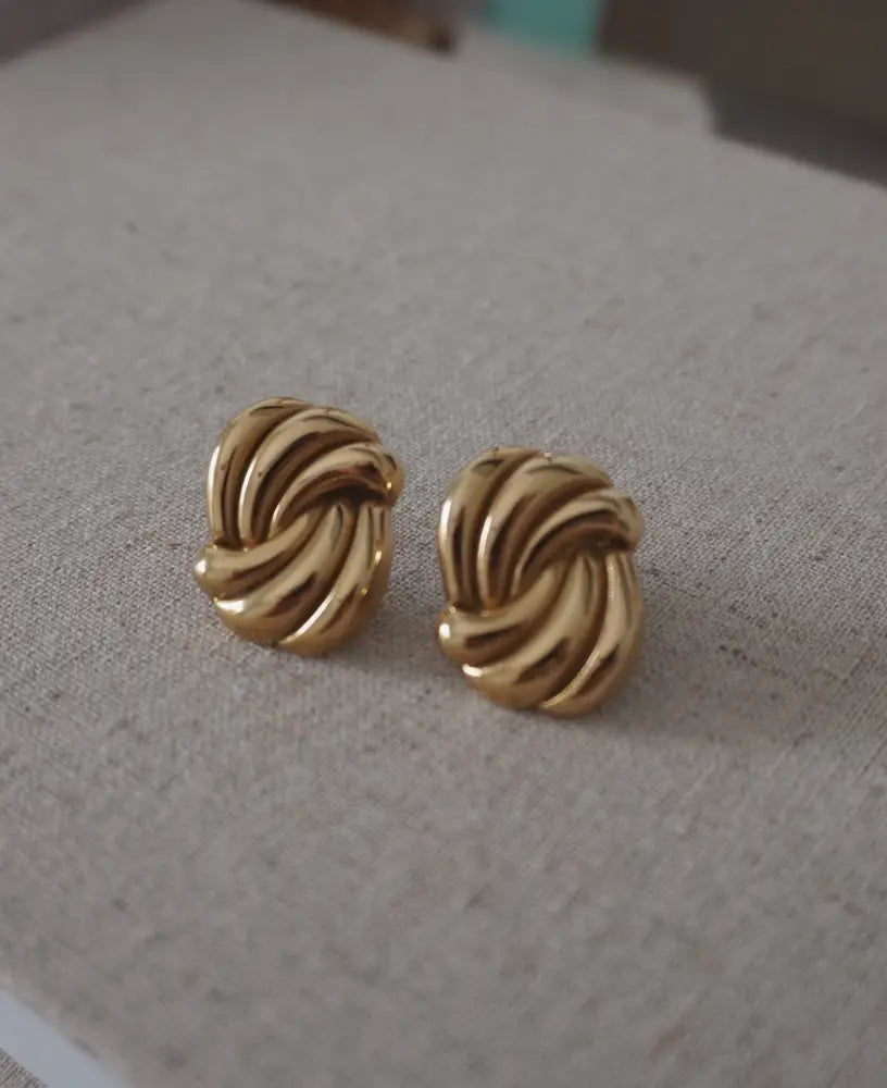 Eternal gold twisted knot stud earrings in gold tone with polished metallic finish and elegant design