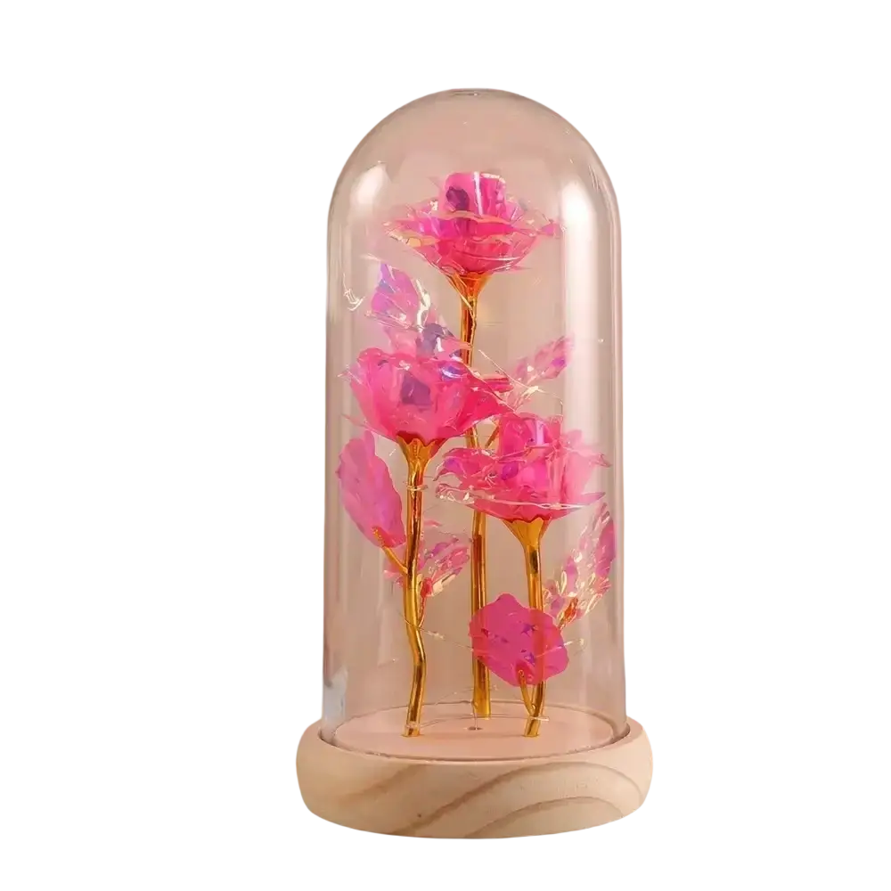 Delicate pink gold rose arrangement with led light encased in a clear glass dome on a light wood base