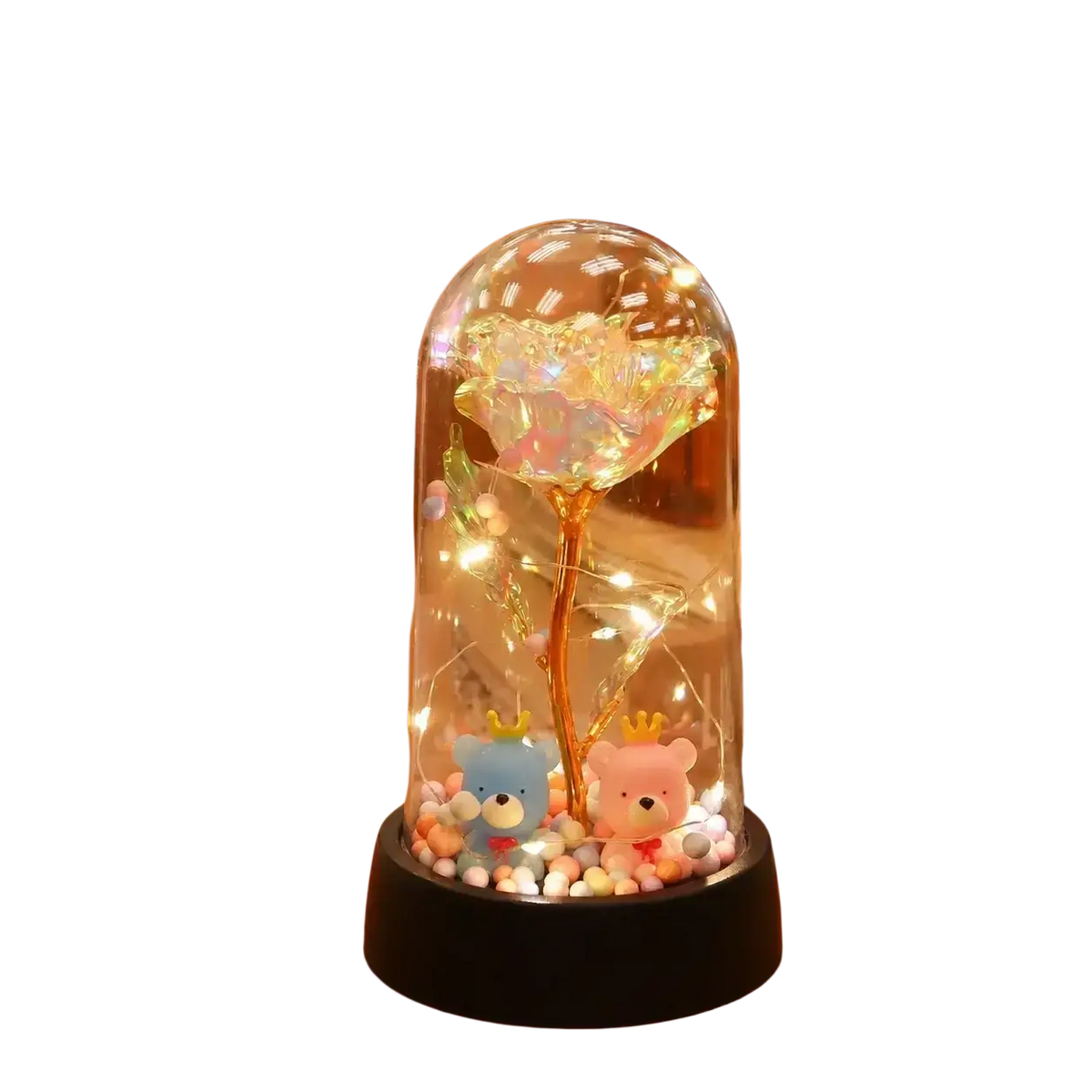 A glowing gold rose encased in a clear glass dome with led light and teddy bear figurines at the base