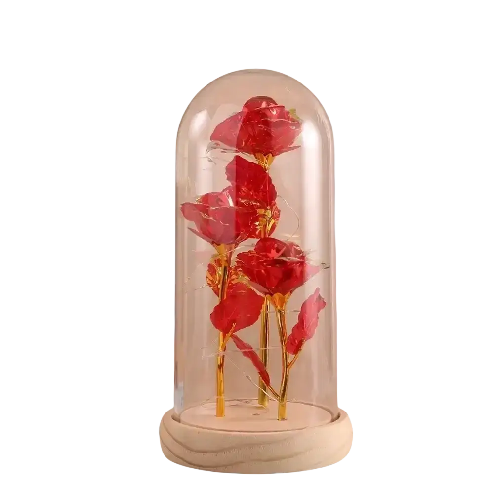 A set of vibrant red gold roses with led light displayed inside a clear glass dome on a white marble base