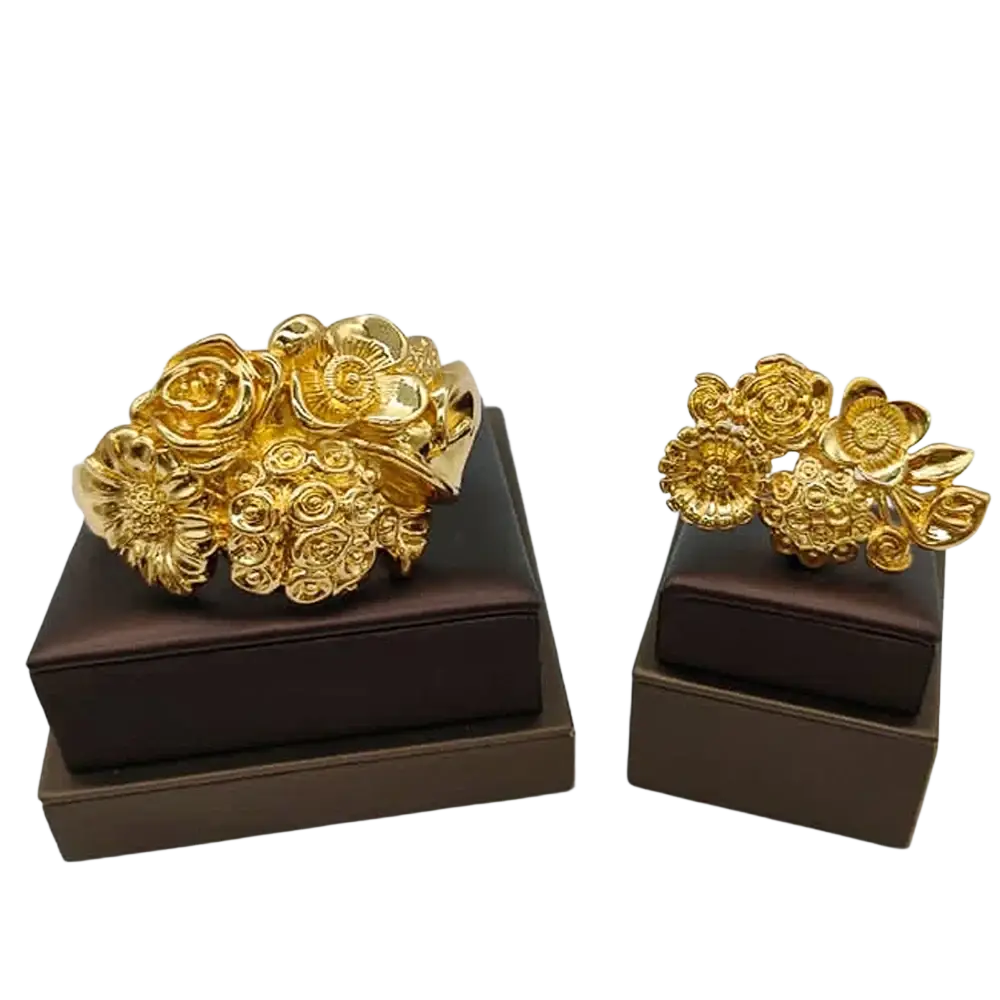 Gold floral cuff bracelet and matching earrings displayed on brown boxes ethiopian arabic hand luxury jewelry color bangles