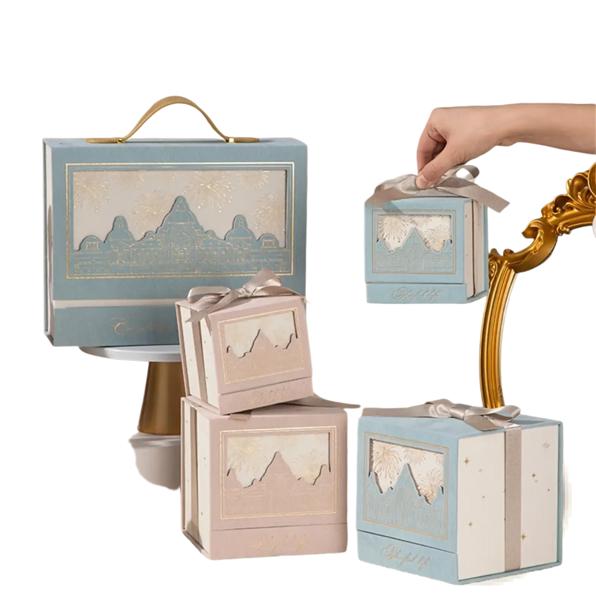 European style wedding gift boxes in pastel blue and beige with gold-trimmed mountain cutouts and satin ribbon ties