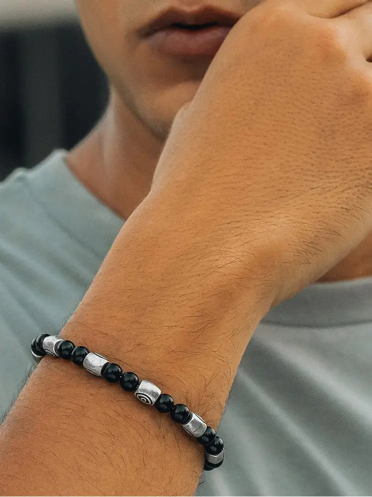 Rtzn black obsidian and silver evil eye protection bracelet with black and silver beads and spiral design on metallic bead