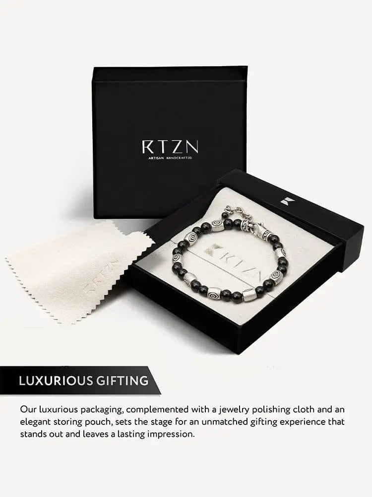 Rtzn black obsidian and silver evil eye protection bracelet with black and silver beads and intricate spiral metallic spacers