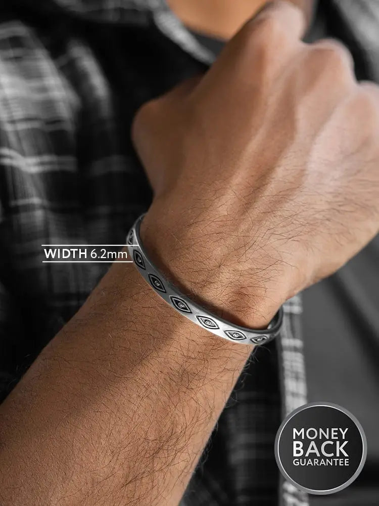 Silver-toned stainless steel cuff bracelet with teal geometric evil eye motifs in a repeating pattern