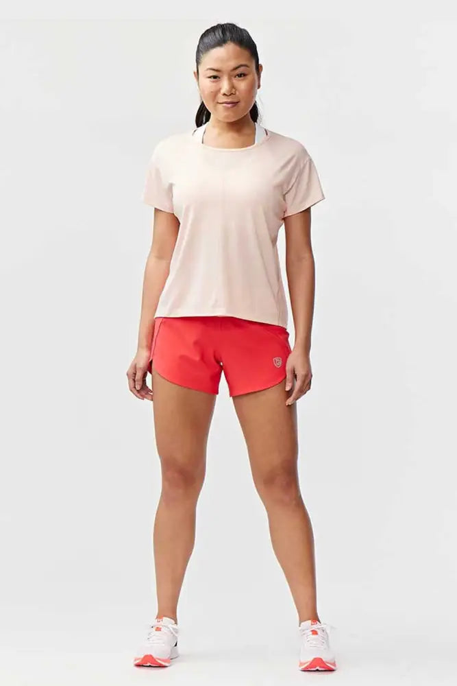 A woman wears Excel women’s black camouflage athletic workout shorts with a pale pink short-sleeved top