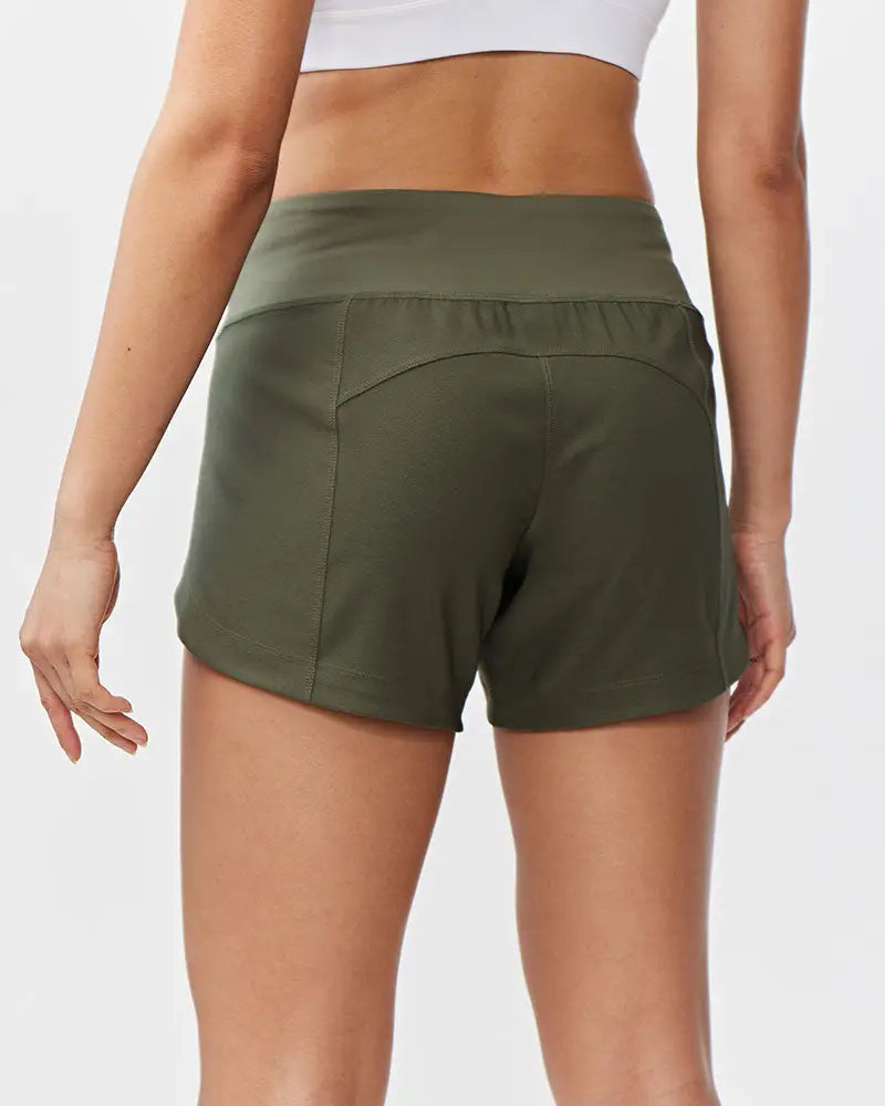 Olive green excel women’s athletic shorts with high-waisted elastic band and subtle side pockets for workouts