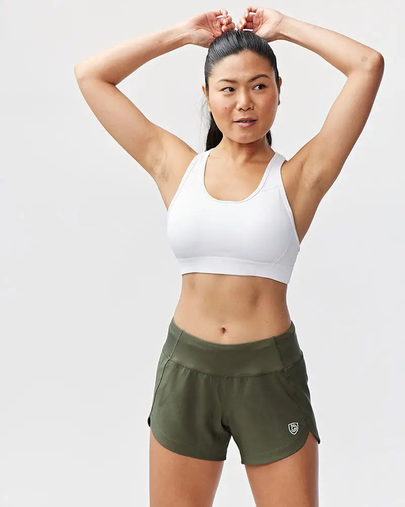 Olive green athletic shorts with high waisted elastic waistband and small logo on lower right leg for women