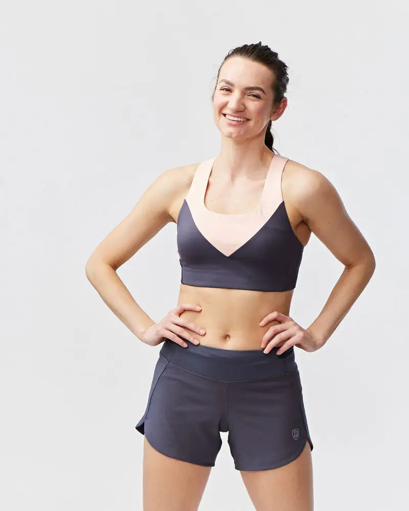 Excel women’s black camouflage athletic workout shorts paired with a dark gray and pink two-toned sports bra