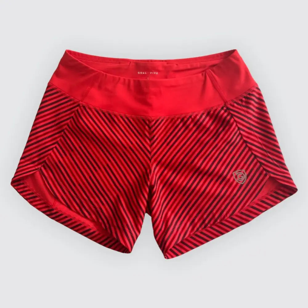Red athletic shorts with black diagonal stripes and goal five logo on inner waistband for women’s workout use
