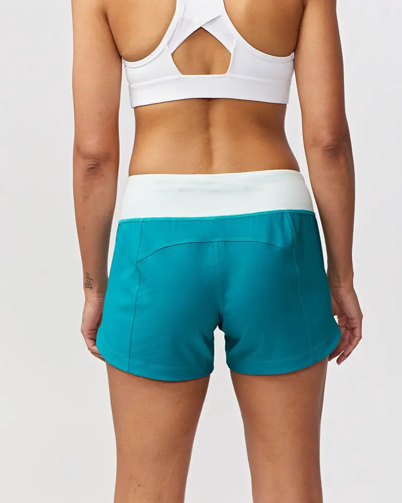 Teal athletic shorts with white elastic waistband designed for women’s workout with black camouflage accents