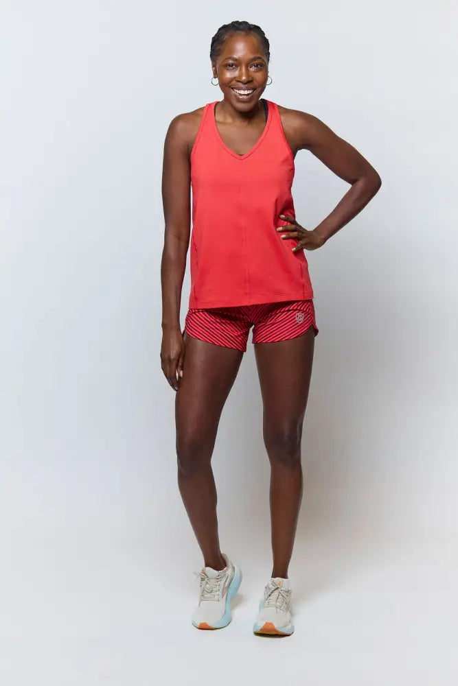 A vibrant red sleeveless athletic tank top with a v-neckline paired with excel women’s black camouflage workout shorts