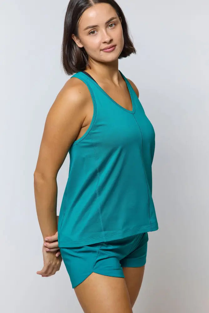 Teal sleeveless tank top with v-neckline and matching shorts paired with excel women’s black camouflage athletic workout shorts