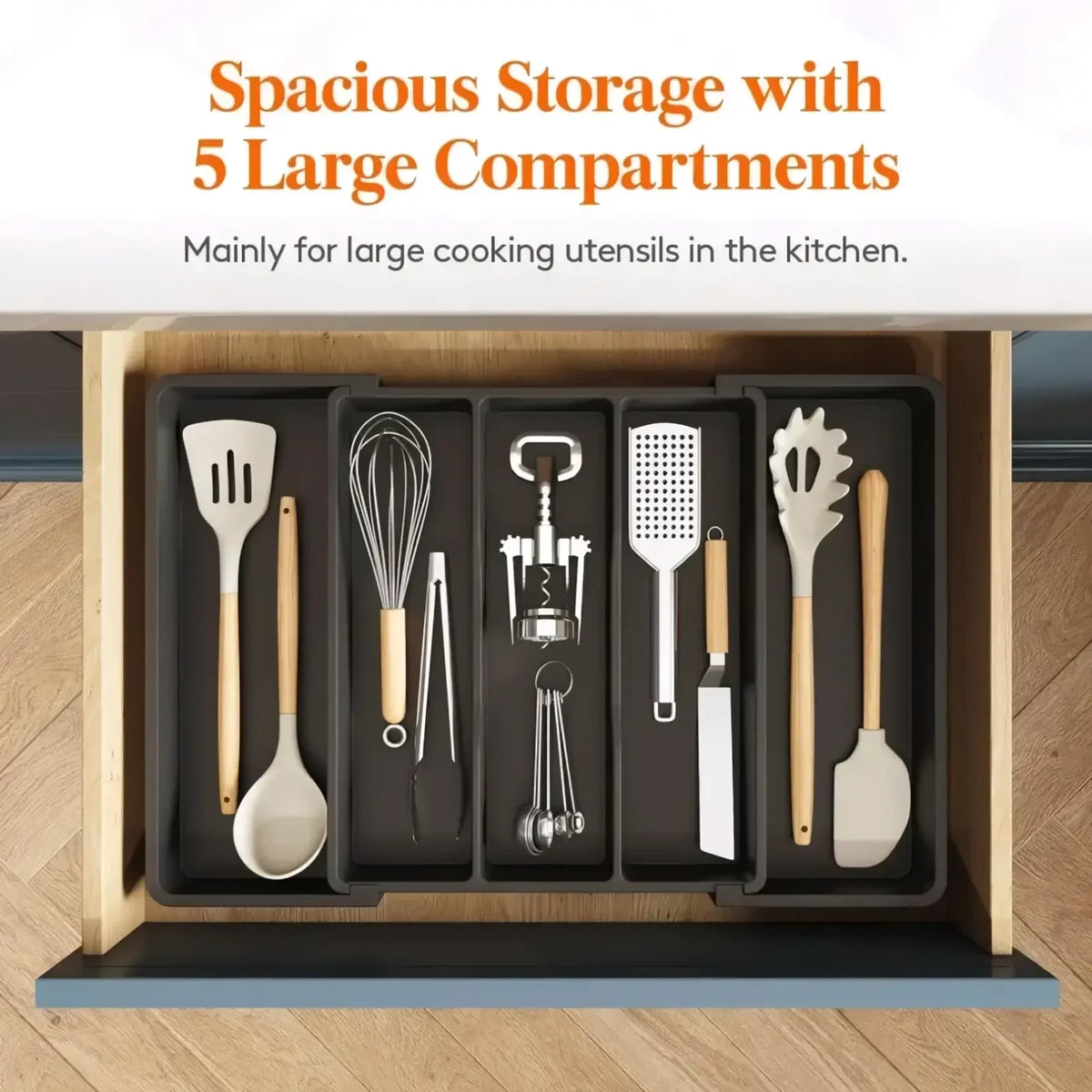Black silicone expandable silverware drawer organizer with five large compartments holding spatulas whisks and corkscrews