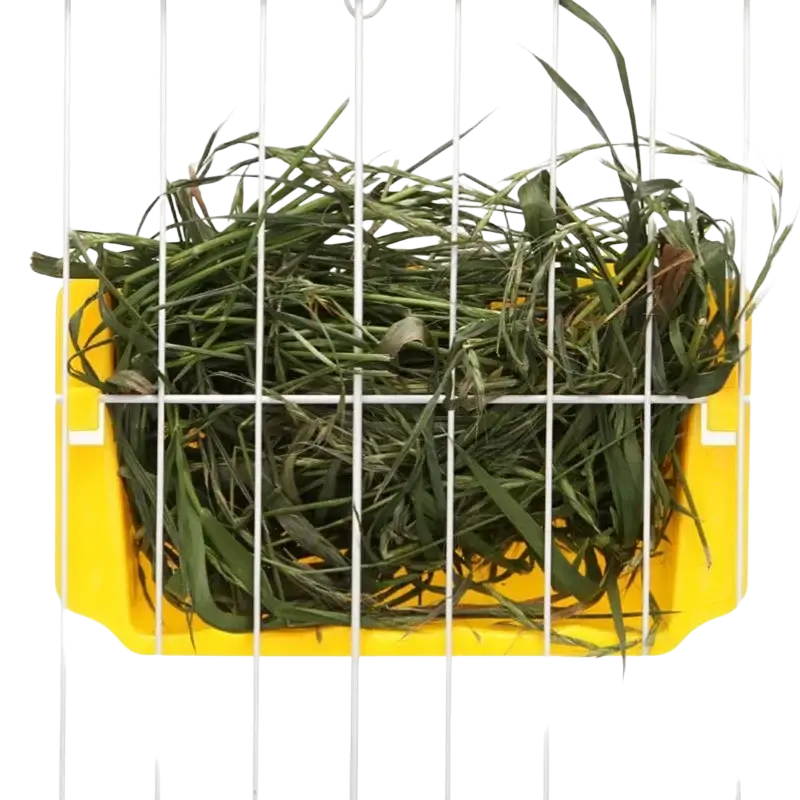 Yellow plastic external rabbit hay feeder food rack filled with green grass strands for easy feeding