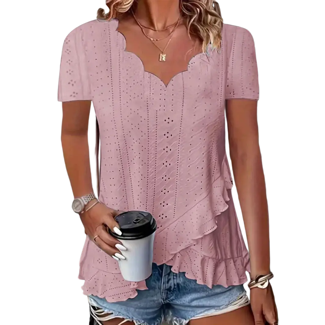 A soft pink eyelet ruffle v-neck blouse with short sleeves and layered ruffle hem detail