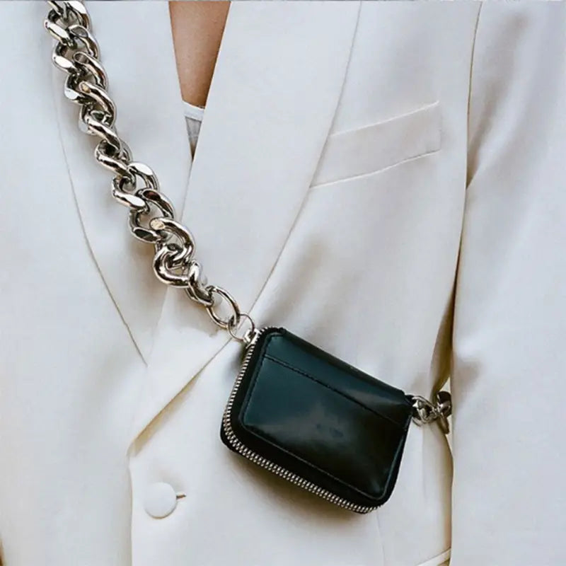 Black leather mini waist bag featuring a zippered closure and a chunky silver chain strap.