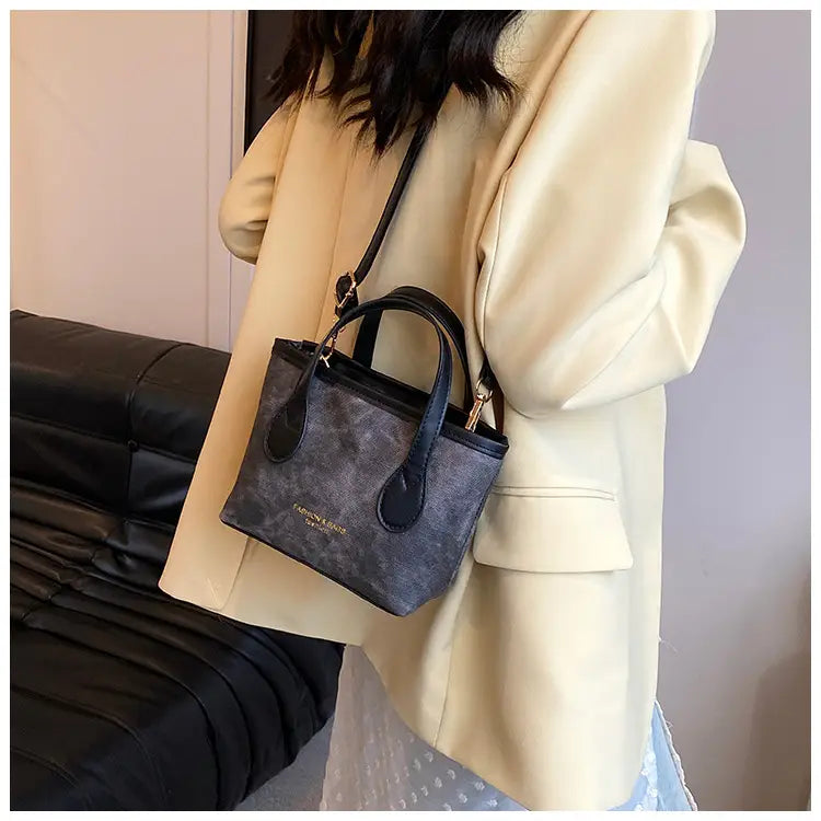 Black textured mini tote bag with contrasting black leather handles and gold-tone hardware from the Retro Bucket Bag textured canvas shoulder handbag collection.