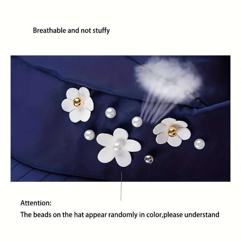 白い布の花(ゴールドのセンター)と散りばめられたパールのようなビーズをあしらった、ダークブルーのキルティング仕立ての軽量カジュアル野球帽サンハット(ユニセックス)。
