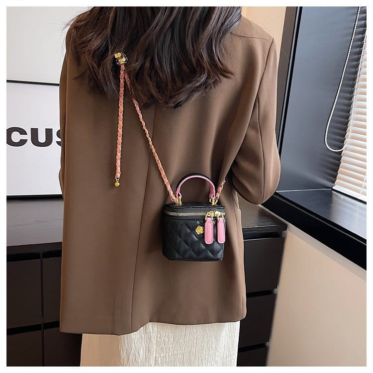 black quilted mini crossbody bag with pink braided strap and gold-tone hardware accents made of pu leather featuring a diamond pattern design